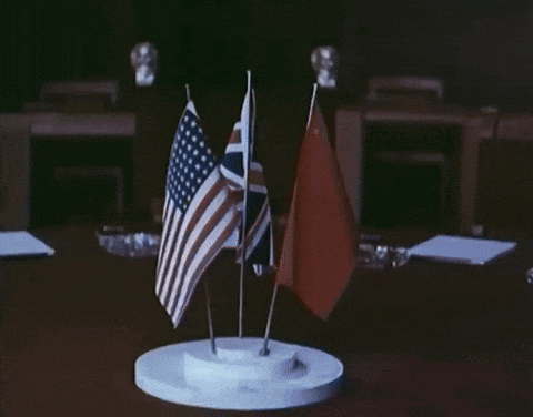 three small flags on a table including the american flag and the british flag
