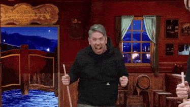 a man holding a pool cue in front of a saloon