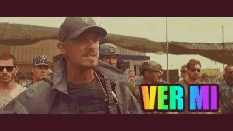 a man in a hat stands in front of a group of soldiers and the word ver mi is displayed in rainbow colors