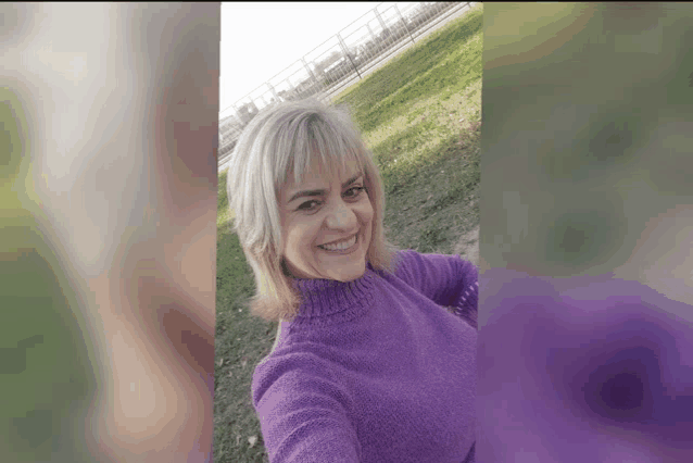 a woman wearing a purple sweater is smiling for the camera