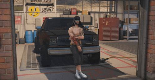 a man with a tattoo on his arm stands in front of a truck