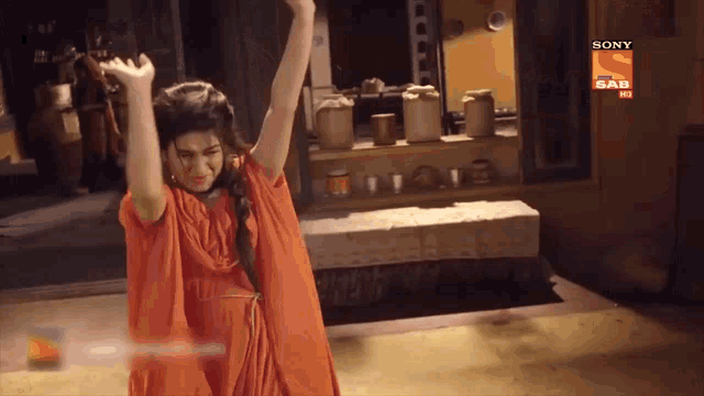 a woman is dancing in front of a sign that says sony sab hd
