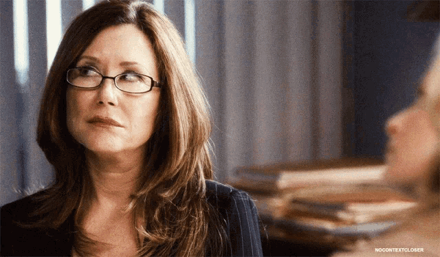 a woman wearing glasses is looking at another woman in a nocontentcloser photo