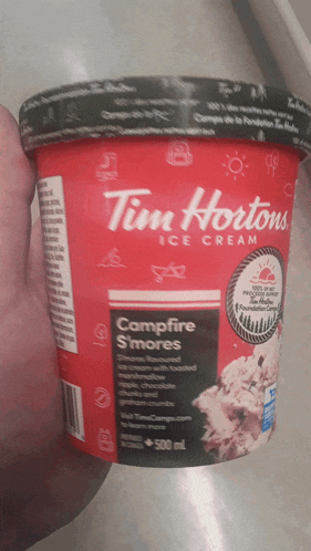 someone is holding a tub of tim hortons ice cream