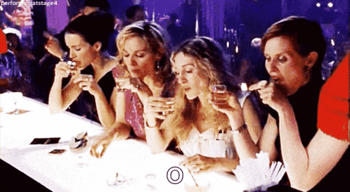 a group of women sitting at a table drinking from glasses with a circle around them that says perform at stage 4