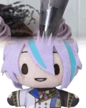 a stuffed animal with purple hair and a blue stripe on it 's forehead is being decorated with frosting .