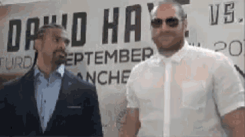 two men standing in front of a sign that says david hay vs