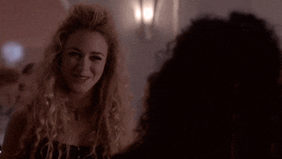a woman with curly hair and a cross necklace