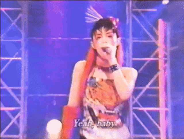 a woman with red hair is singing into a microphone with the words yeah baby written below her