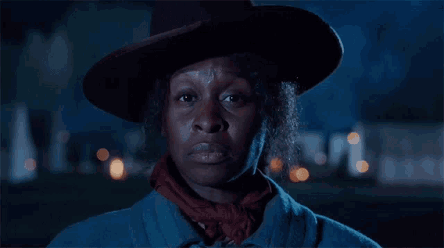 a woman wearing a cowboy hat and a red scarf