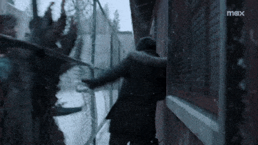 a person standing in front of a fence with a max logo on the bottom