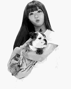 a black and white photo of a woman holding a cat .