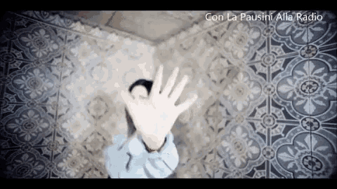 a person covering their face with their hands with the words con la pausini alla radio written on the bottom