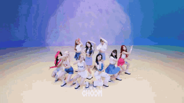 a group of girls are dancing in front of a blue background with choom written on it
