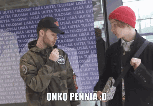 two men standing in front of a sign that says ' onko pennia ' on it