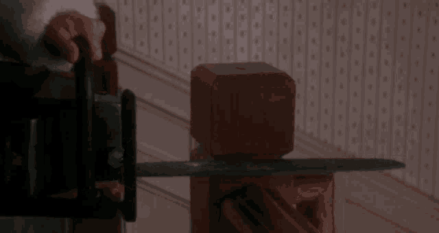 a person using a chainsaw to cut a wooden post