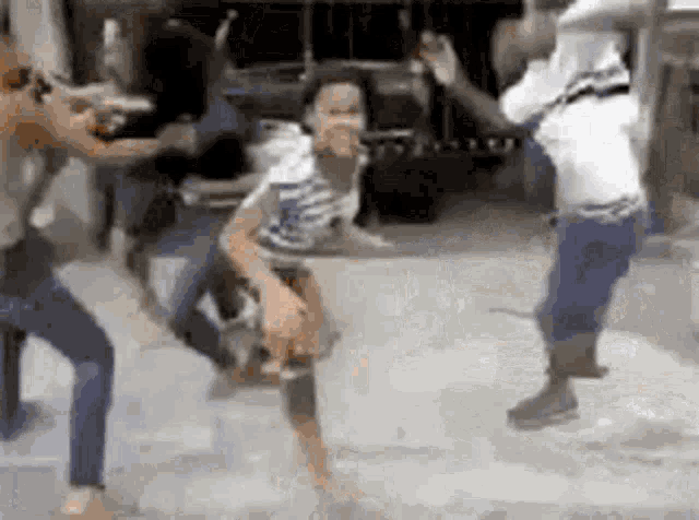 a group of people are dancing on a street in front of a truck .