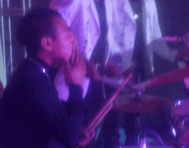 a man playing drums in a dark room