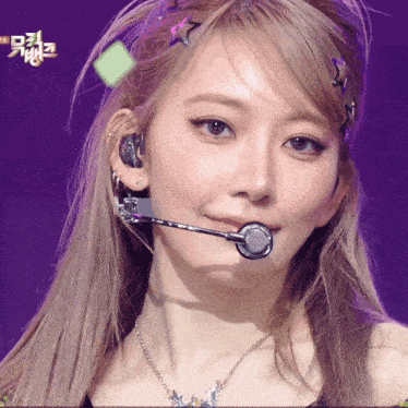 a close up of a woman 's face with a microphone on her mouth