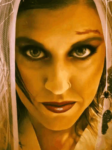 a close up of a woman 's face with a veil covering her head