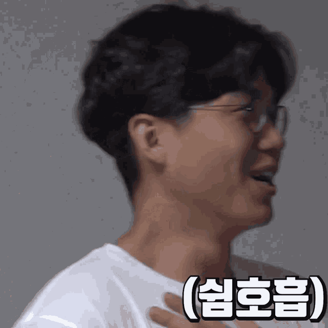 a close up of a man wearing glasses and a white shirt with chinese writing on it