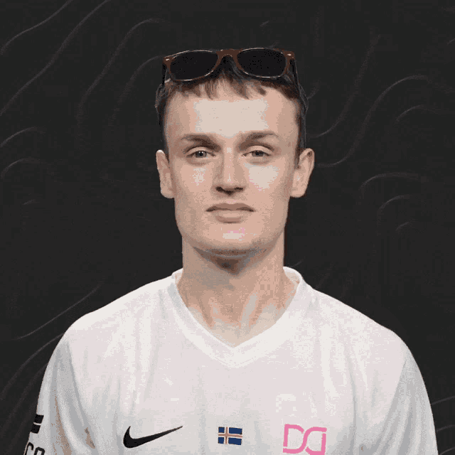 a man wearing sunglasses and a white shirt with the letter dg on it