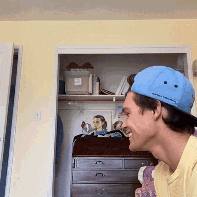 a man wearing a blue hat that says point of a thousand miles on it