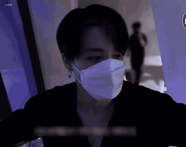 a man wearing a face mask is standing in front of a purple wall