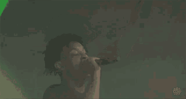 a man is singing into a microphone on a stage .