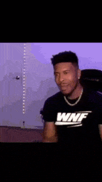 a man wearing a black shirt with the word wnf on it