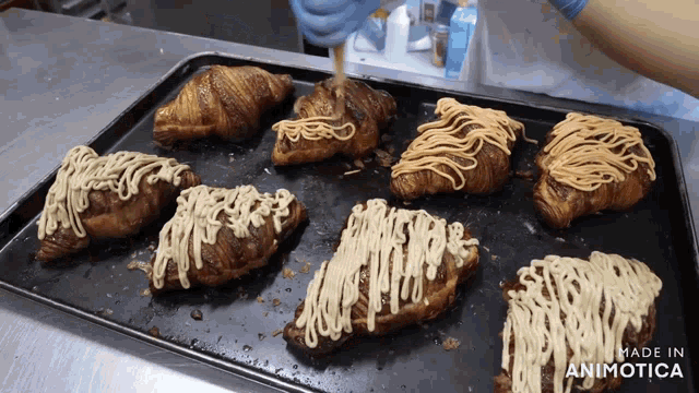 a bunch of croissants are sitting on a tray that says made in animonica