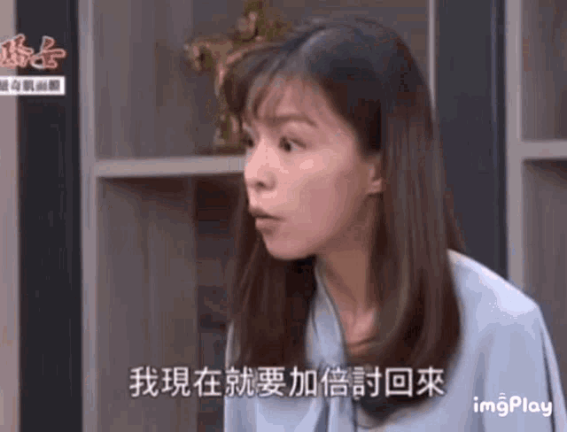 a woman in a blue shirt is talking in a foreign language