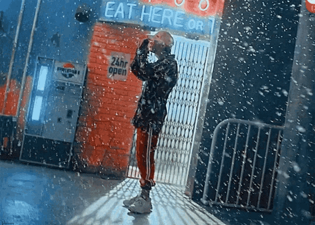 a man standing in front of a sign that says eat here or 1