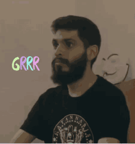 a man with a beard wearing a black shirt that says grrr on it