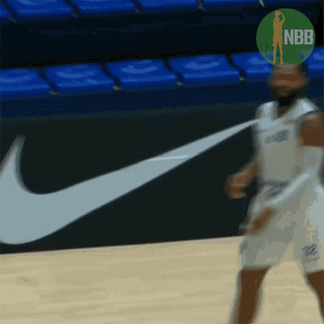 a basketball player is dribbling a basketball in front of a nike logo