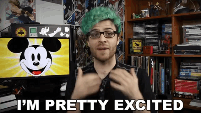 a man with green hair says i 'm pretty excited in front of a mickey mouse monitor