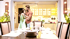 a man and woman hugging in a dining room