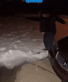 a man is shoveling snow in front of a ford car