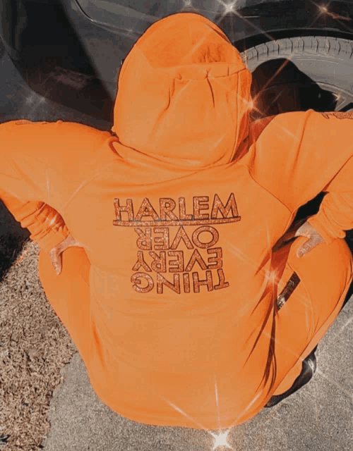 a person wearing a hoodie that says harlem over every thing