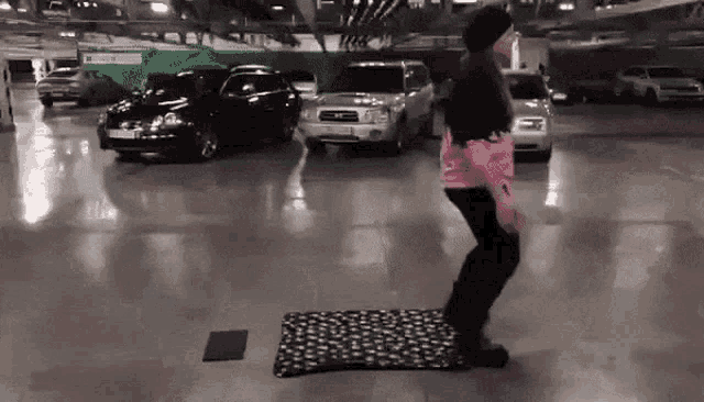 a person is jumping on a mat in a parking lot