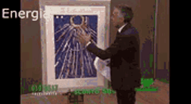 a man in a suit is standing in front of a framed picture with the word energie written on it