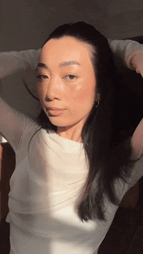 a woman in a white shirt is looking at the camera