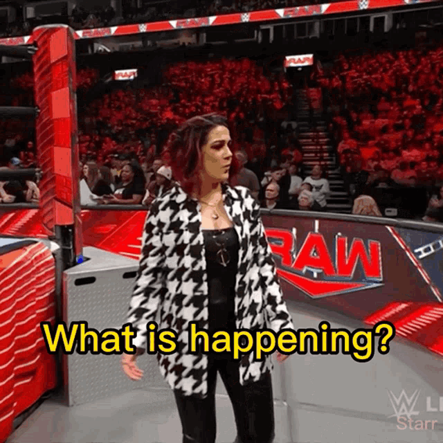 a woman standing in front of a raw sign asking what is happening
