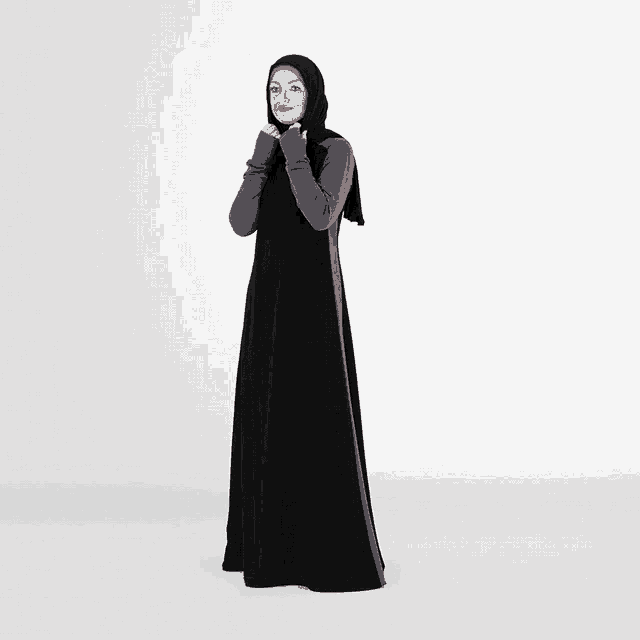 a woman wearing a hijab and a black dress with gray sleeves