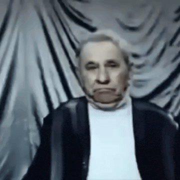 a man in a black jacket and white shirt is making a funny face
