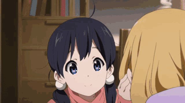 a girl with black hair and blue eyes is talking to another girl with blonde hair