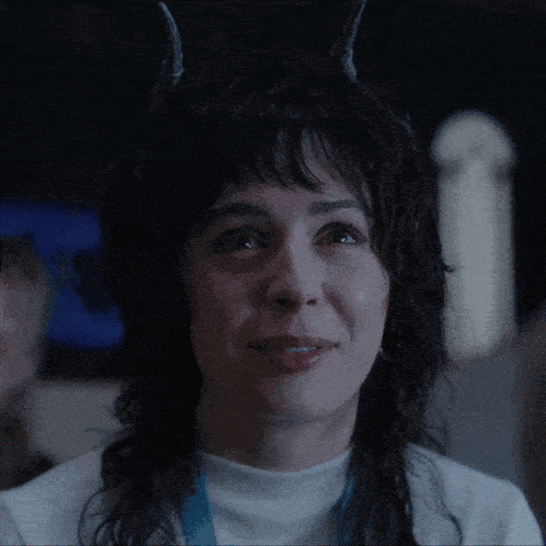 a woman with horns on her head is smiling and says good girl