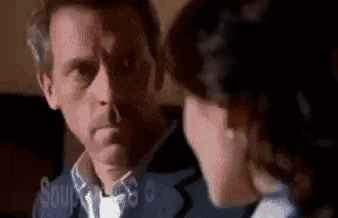 a man and a woman are standing next to each other and talking to each other .
