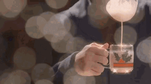 a person is pouring maple syrup into a cup of coffee .
