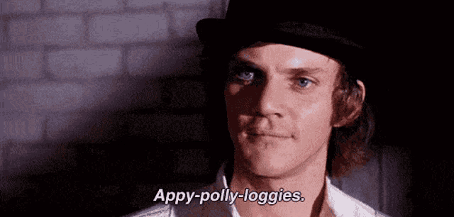a man wearing a top hat and a white shirt is talking .